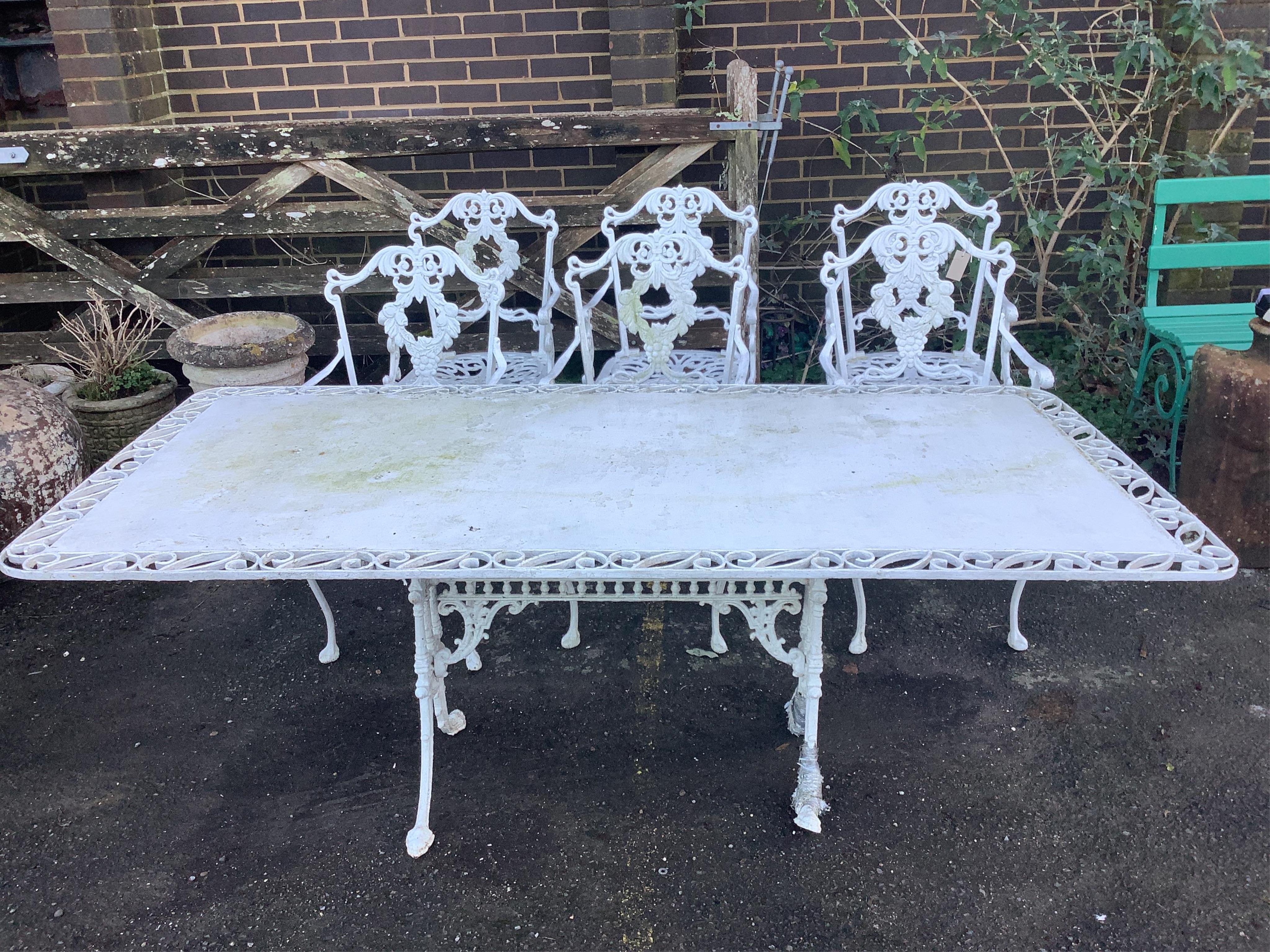 A white painted cast aluminium garden table, width 183cm, depth 92cm, height 71cm, and six chairs. Condition - fair